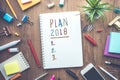 Plan 2018 message with notepad paper on wooden table and supplies