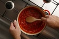 Plan view of a pot of traditional gormet tomato sauce and wooden spoon