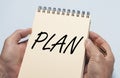 Plan word on notebook in male hands over blue table Royalty Free Stock Photo