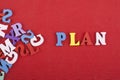 PLAN word on red background composed from colorful abc alphabet block wooden letters, copy space for ad text. Learning english Royalty Free Stock Photo