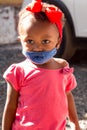 A Little toddler wearing a protective mask while waiting for food