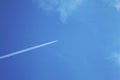 Plane in the blue sky with white clouds. The aircraft leaves traces Royalty Free Stock Photo