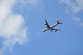 A plane in the clear blue sky with clouds Royalty Free Stock Photo