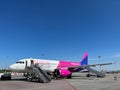 Plane of the company Wizz Air with a ramp stands in the airport