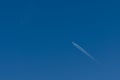 plane with contrails in a blue sky Royalty Free Stock Photo