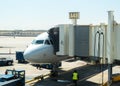 Plane docked at airport terminal connected with passenger boarding bridge connecting for boarding