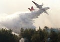 Plane drops water on a forest fire Royalty Free Stock Photo