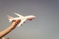 Plane in female hand clear blue sky background copy space. Travel and vacation. Book tickets now. Toy white plane fly Royalty Free Stock Photo