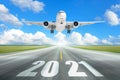 The plane flies over the runway with the inscription 2021. The concept of meeting the new year Royalty Free Stock Photo