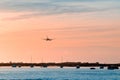 The plane flies to the airport over the river in the city of Faro in Portugal. silhouettes of airplanes and airport, boats in the Royalty Free Stock Photo