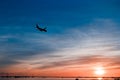 The plane flies to the airport over the river in the city of Faro in Portugal. silhouettes of airplanes and airport, boats in the Royalty Free Stock Photo