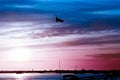 The plane flies to the airport over the river in the city of Faro in Portugal. silhouettes of airplanes and airport, boats in the Royalty Free Stock Photo