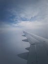 Plane Flight Through The Dense Foggy Clouds, Vertical Shot. Airplane Wing Seen Through The Window