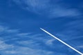 a plane flying against a blue sky with Cirrus Cumulus clouds Royalty Free Stock Photo