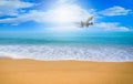 Plane flying on blue sky with cloud background over beach