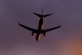 Plane flying through clouds towards sunset in the sky. Jet aircraft. Royalty Free Stock Photo