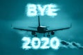 A plane flying into the distance. Cloud-shaped inscription - BYE 2020 Royalty Free Stock Photo