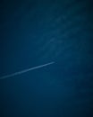 Plane flying at a high altitude in a clear blue sky leaving a white smoke trace Royalty Free Stock Photo