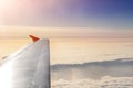 Plane flying over clouds at dawn. Airplane wing over beautiful cloudscape during dramatic colorful sunset or sunrise. Travel and Royalty Free Stock Photo