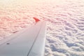 Plane flying over clouds at dawn. Airplane wing over beautiful cloudscape during dramatic colorful sunset or sunrise. Travel and Royalty Free Stock Photo