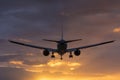 Plane flying towards the runway during a cloudy sunrise. Royalty Free Stock Photo