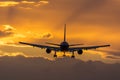 Plane flying towards the runway during sunrise. Royalty Free Stock Photo