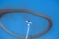 Plane flying up trough a ring of smoke