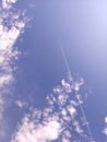 Blue sky with clouds and a plane.