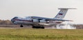 Plane Ilyushin Il-76TD NATO reporting name: Candid is landing. Smoke from under the chassis. Airplane`s fuselage. Royalty Free Stock Photo