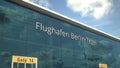 Landing airplane reflects in the modern windows with Flughafen Berlin Tegel or Berlin-Tegel Airport text. 3d rendering