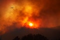 Plane leaving trail of chemicals to fight wildfire against dramatic sunset