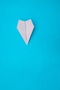 A plane made of paper on a blue background.The plane is made by hand. Origami paper. Royalty Free Stock Photo