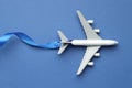 Plane model and ribbon as flight path on blue background, top view Royalty Free Stock Photo