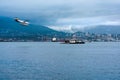 Plane moving to water next to Floating Chevron Station with North Vancouver on the background. Royalty Free Stock Photo