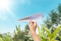 Plane paper in children hand in farm and blue sky