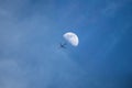 Plane passing through the Moon from bottom view with long conden Royalty Free Stock Photo