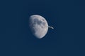 Plane passing moon Royalty Free Stock Photo