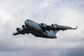 Plane Royal Airforce RAF Boeing C-17A Globemaster III, sorrowing through the bright blue sky Royalty Free Stock Photo