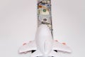 The plane on the runway from dollar bills. Airplane and dollars on a white background. Passenger airplane model on dollars and Royalty Free Stock Photo