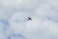 plane in the sky full of cattered clouds