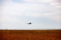 Plane takes off above a farmed field