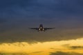 The plane takes off on the background of sunset and flies at dusk Royalty Free Stock Photo
