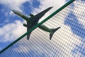 Plane taking off against the background of the fence and the border of the airport. Tourism, business, flight ban