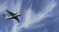 The plane took off into the sky. Airplane flight on a background of blue cloudy sky on a clear sunny day