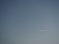 Plane and trail in the evening sky blue. Abstract background on a space or aero theme. Color gradient Royalty Free Stock Photo