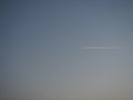 Plane and trail in the evening sky blue. Abstract background on a space or aero theme. Color gradient Royalty Free Stock Photo