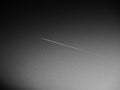 The plane and the trail in the sky is black or gray. Abstract background on a space or aero theme. Increased graininess. Light Royalty Free Stock Photo