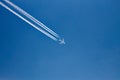 Plane with vapor trails in a blue sky