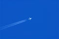 Plane with vapour trails in a blue sky Royalty Free Stock Photo