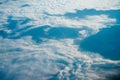 Plane window view of clouds and islands surrounded by sea and airplane wing. Traveling concept Royalty Free Stock Photo